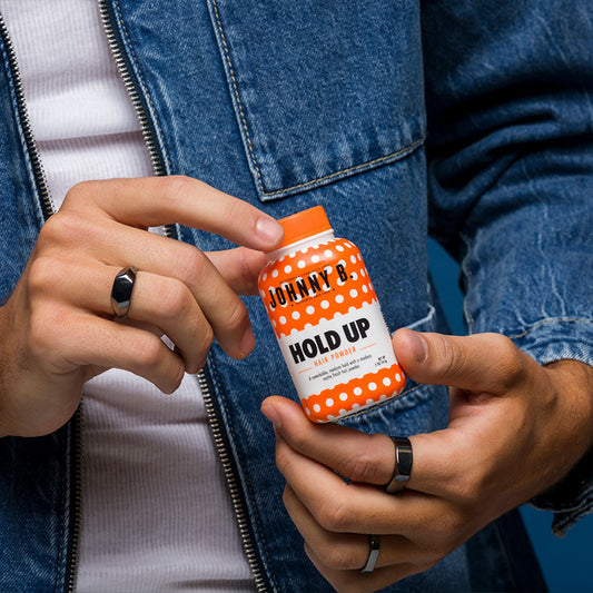 Johnny B Hold Up Hair Powder in 0.5 oz container, styling product with a white powder texture for adding volume and hold.