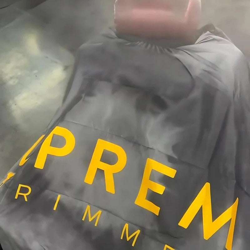 Supreme Trimmer premium barber cape with smoke ring design, lightweight and protective for professional hair cutting and styling.